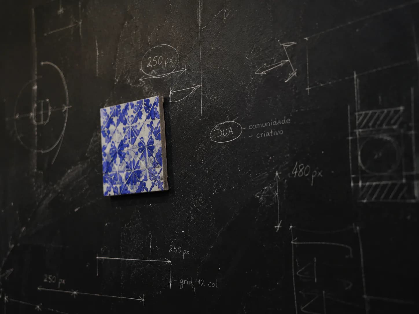 Parede de estúdio com desenho técnico e detalhe de azulejo