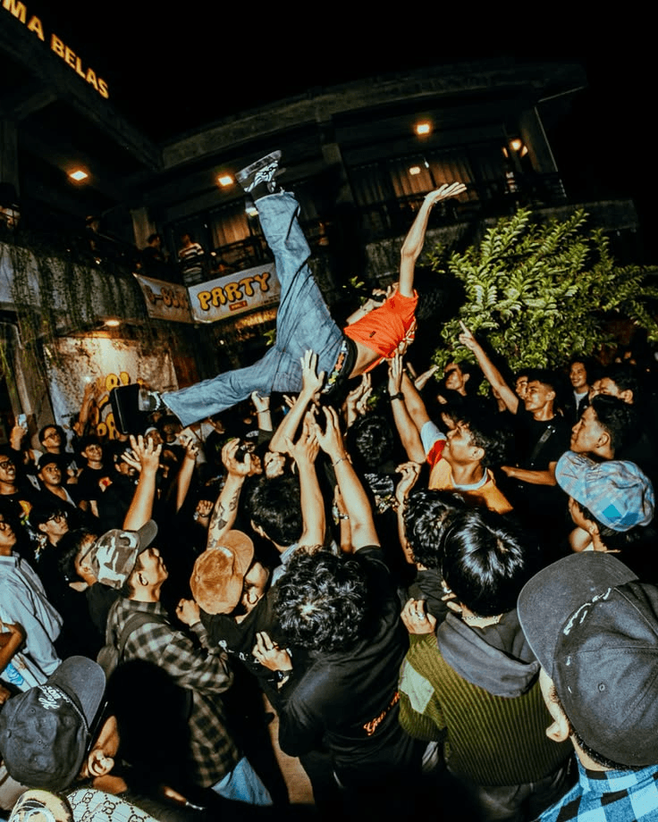 Público a celebrar um concerto, com uma pessoa levantada pela multidão